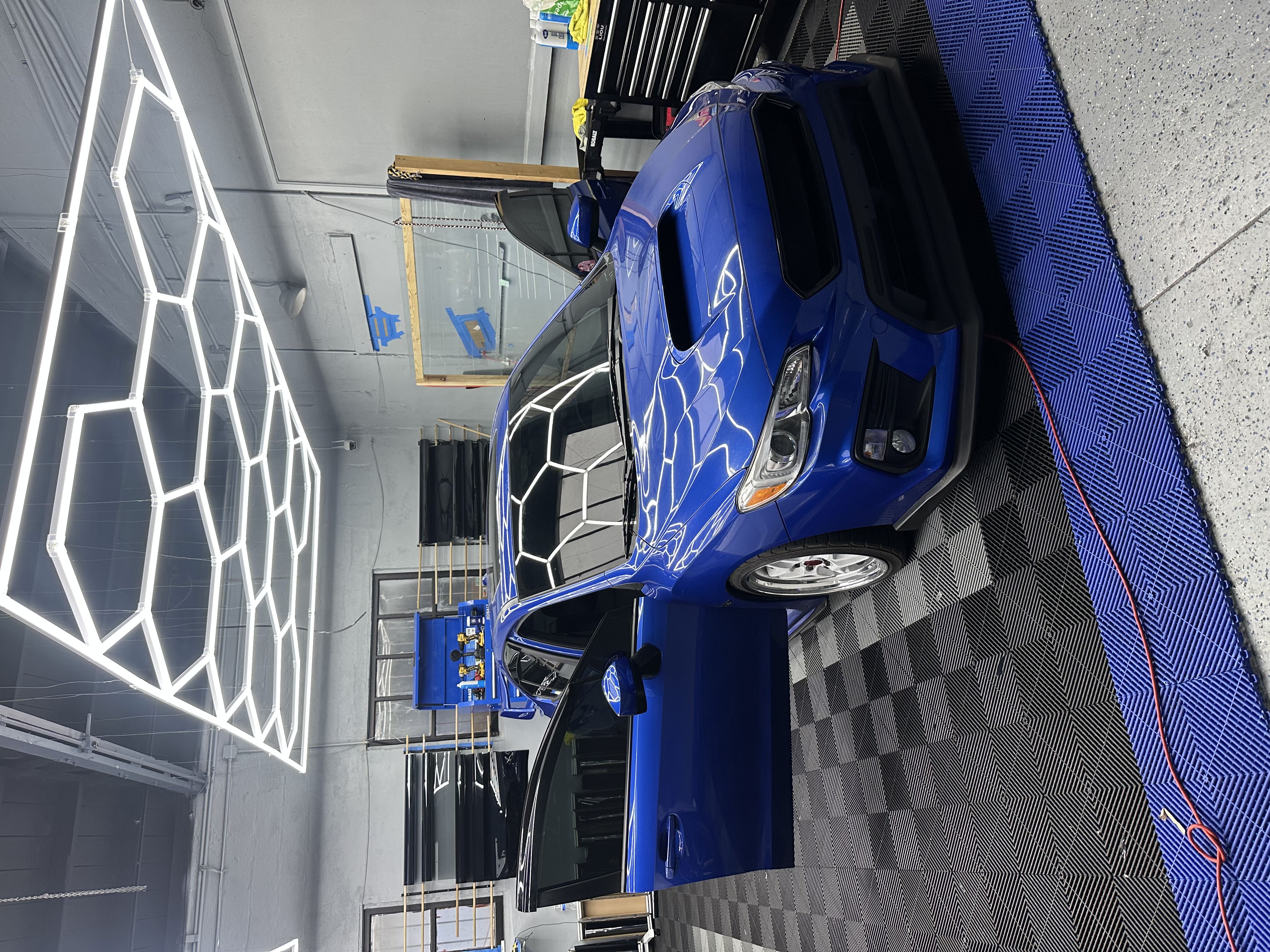 White compact car with mural background